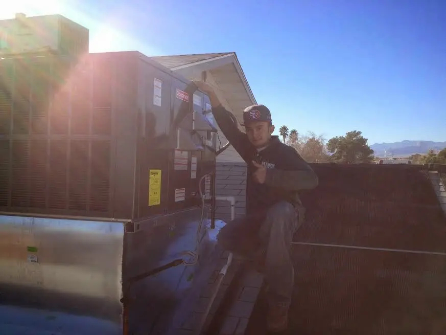 HVAC technician performing Heat Pump Repair on a rooftop unit in Town and Country